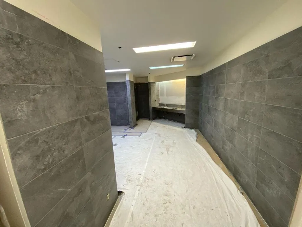 Mapei grout finishing and curing on a commercial bathroom floor